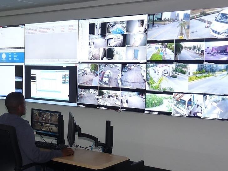 Operador frente a la pared de video del centro de monitoreo, con cámaras en vivo
